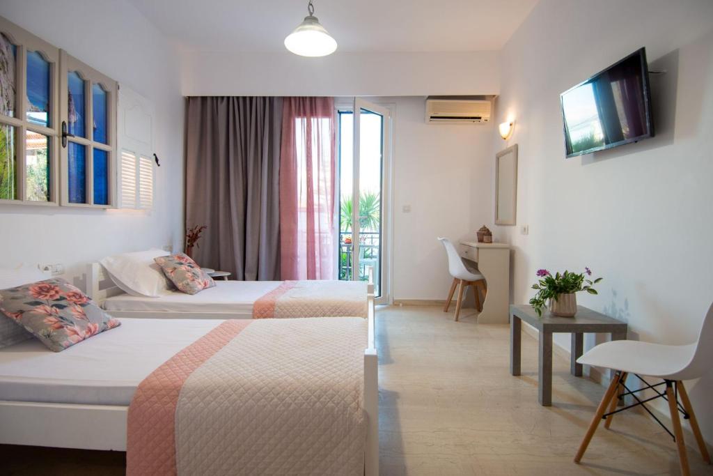 a hotel room with two beds and a television at Kolevri Studios in Laganas