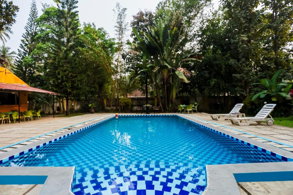 una piscina en un complejo con azulejos azules y blancos en Lemon Zest Oasis By JadeCaps Pvt Pool 6BHK Goa en Nuvem