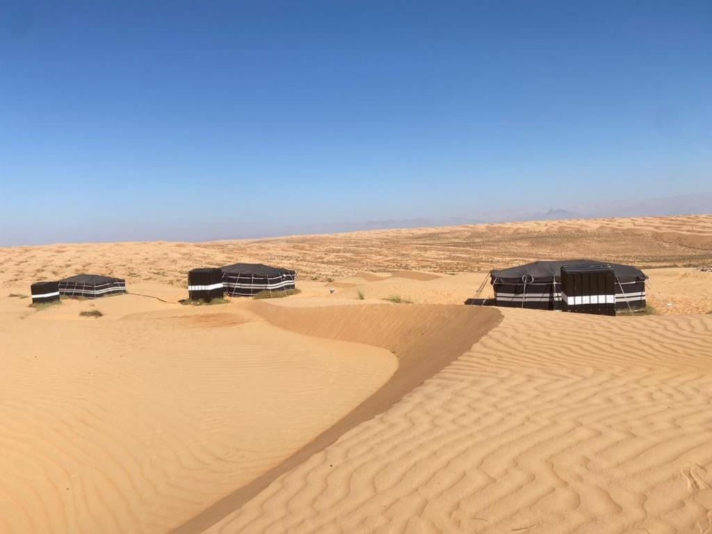 a group of tents in the sand in the desert at Clouds Desert Camp in Bidiyah