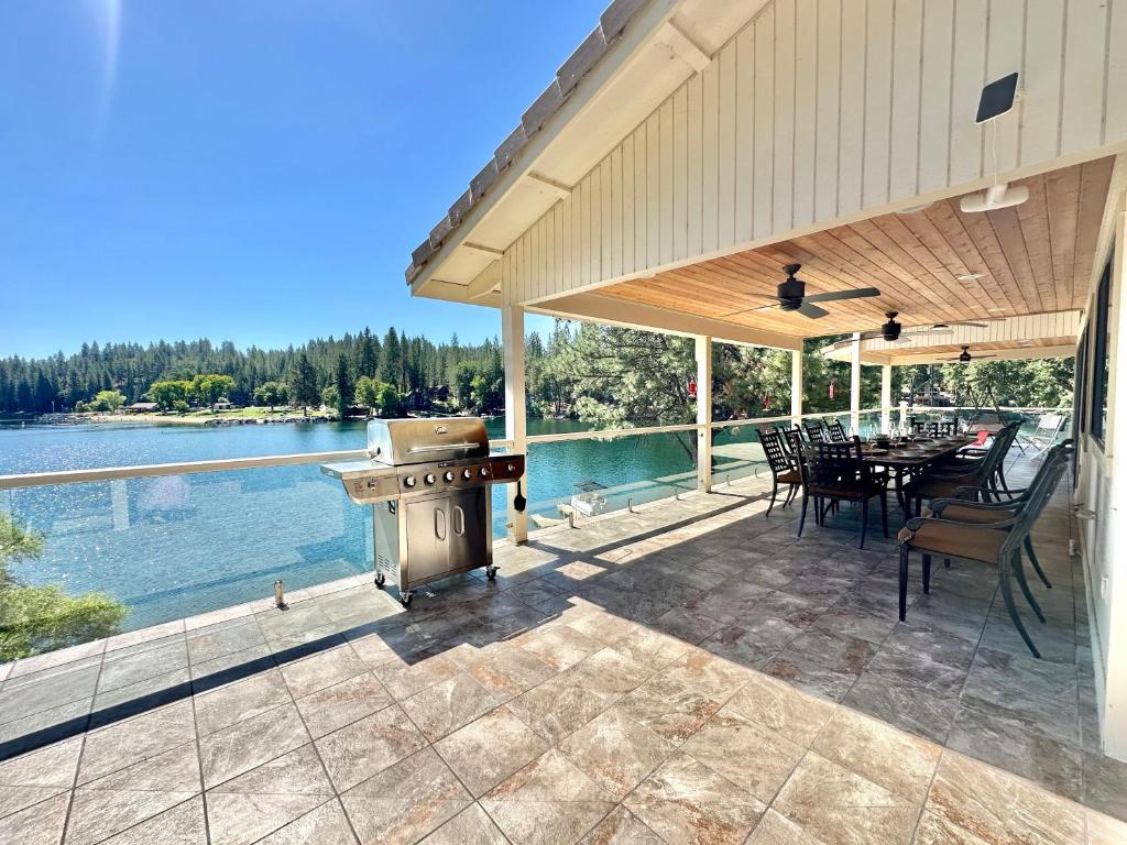 un patio al aire libre con parrilla, mesa y sillas en Luxury Yosemite Lake House, en Groveland