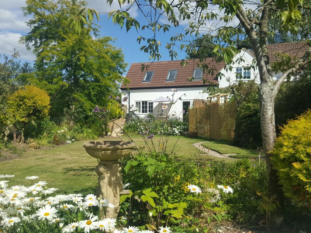 a garden with a bird bath in the yard of a house at 1 Bed in Taunton 75135 in Isle Brewers