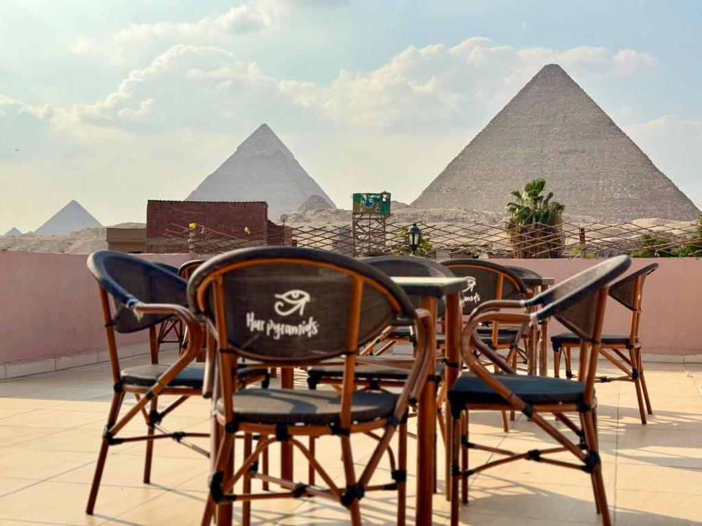 a table and chairs with the pyramids in the background at Hur magic inn in Cairo