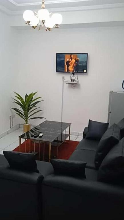 - un salon avec un canapé et une table dans l'établissement Residence Sighaka - Premium VIP Apartment - WiFi, Gardien, Parking, à Douala
