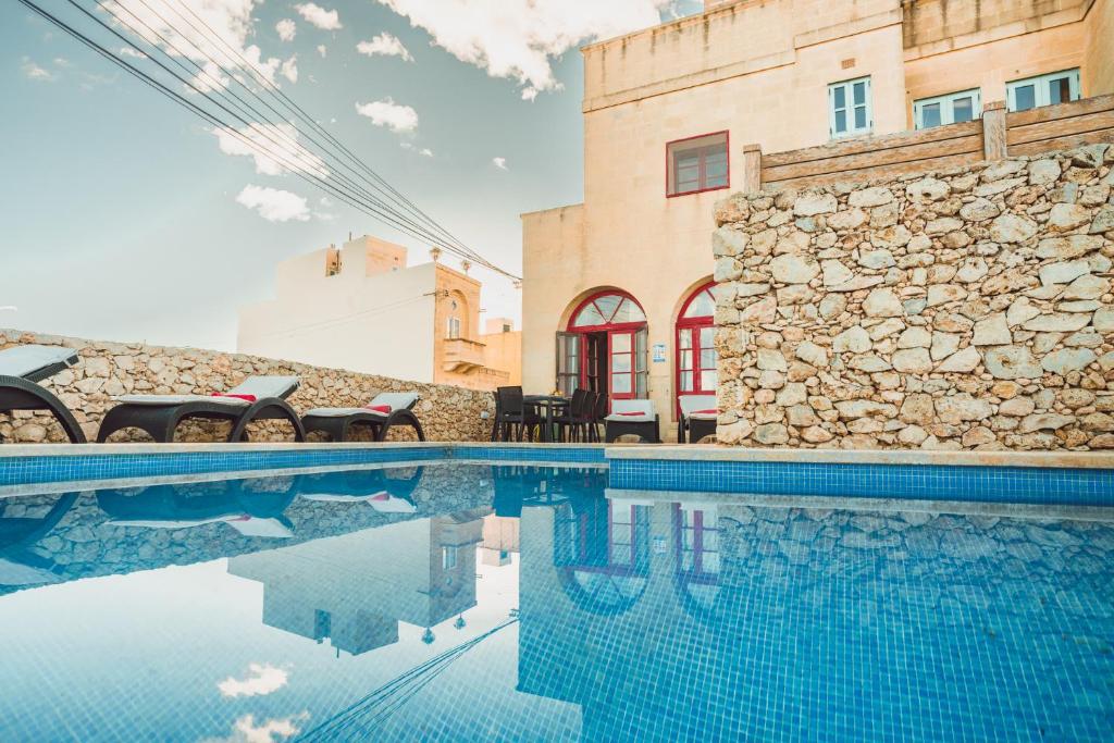 a swimming pool in front of a building at Amaryllis Holiday Home in Qala