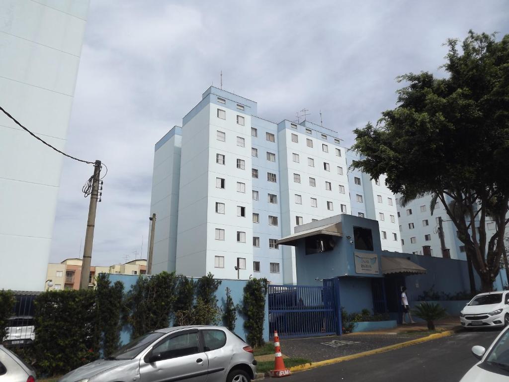 un gran edificio blanco con coches estacionados frente a él en Apartamento inteiro para até 5 pessoas en Campinas