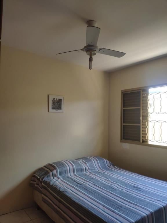 a bedroom with a bed and a ceiling fan at Pousadinha Sophia Verde in Goiânia