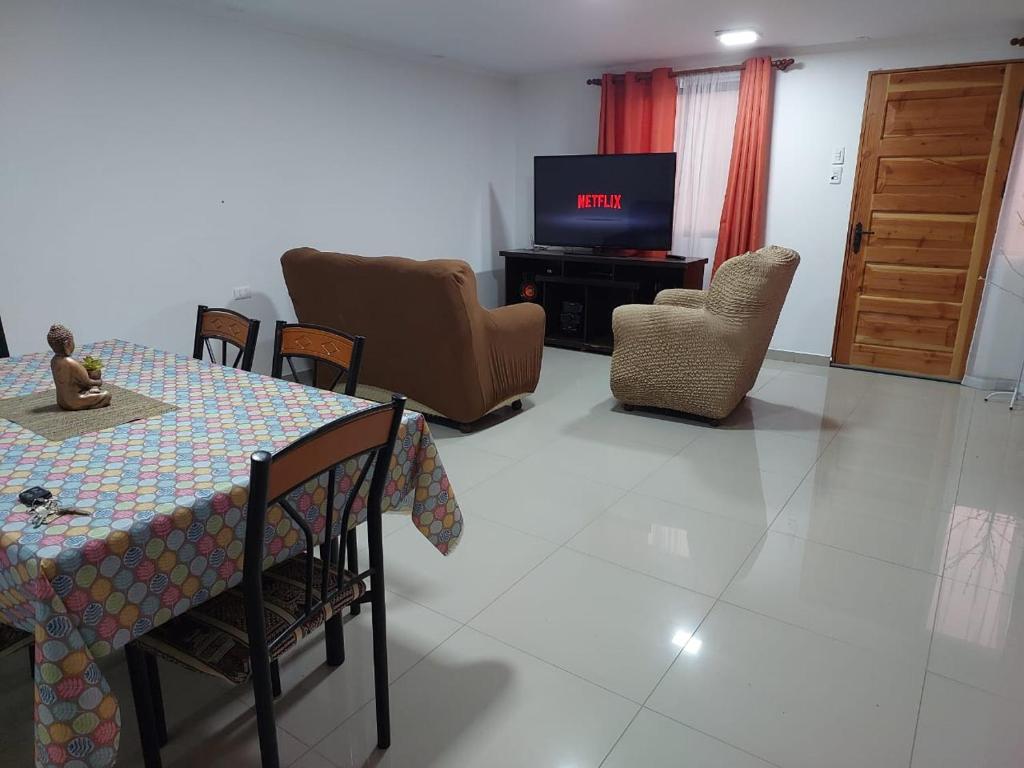 a living room with a table and chairs and a television at Casa Rural Poblado de Acha Arica in Arica