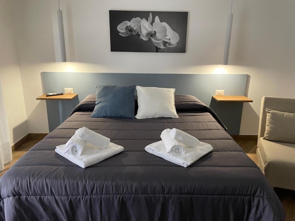 Maiolica Apartment في كالتانيسيتا: غرفة نوم بسرير كبير عليها منشفتين