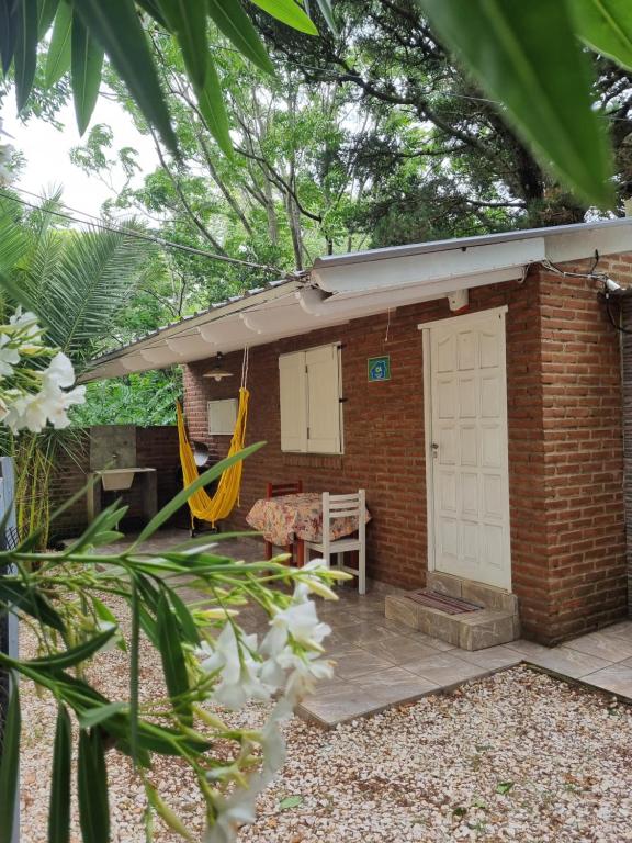 a brick house with a white door and a patio at El buen descanso in Mar de Ajó