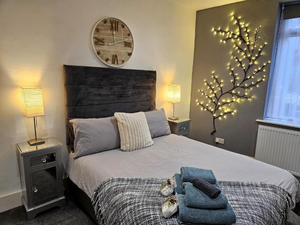a bedroom with a bed with a tree on the wall at East Shore in Hastings