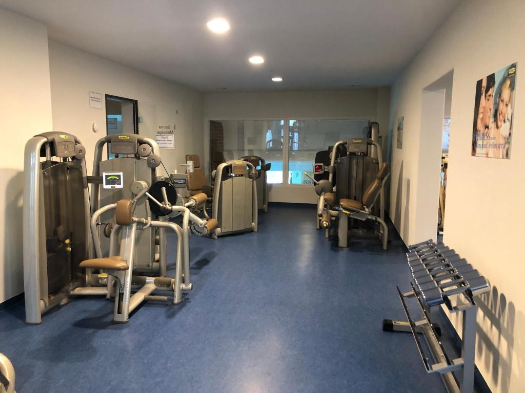 un gimnasio con muchas máquinas de correr en una habitación en Ferienwohnung Bergzeit mit Sauna und Pool, en Sankt Englmar