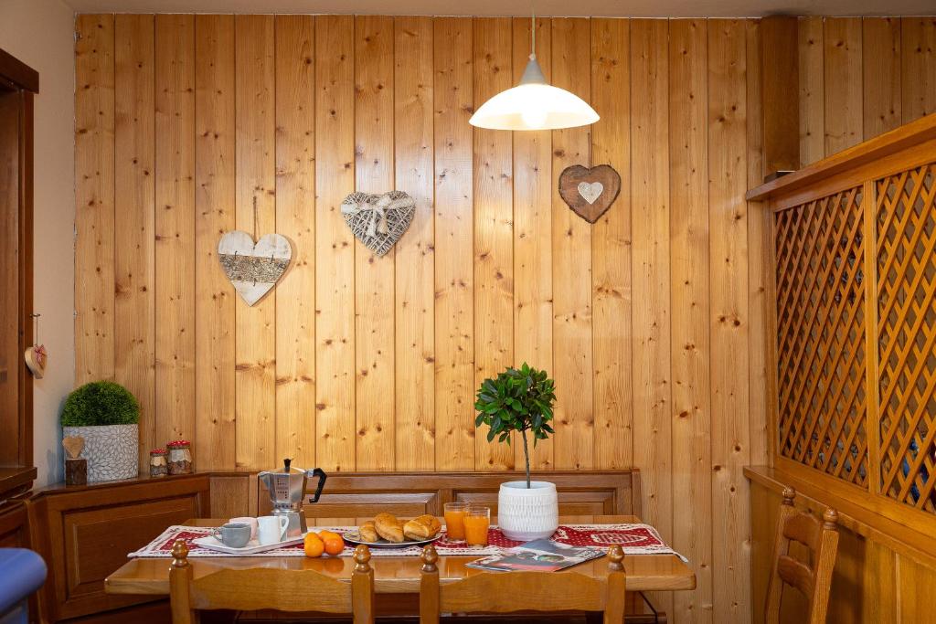 un comedor con una mesa con corazones en la pared en Ciasa de Vich, en Vigo di Fassa