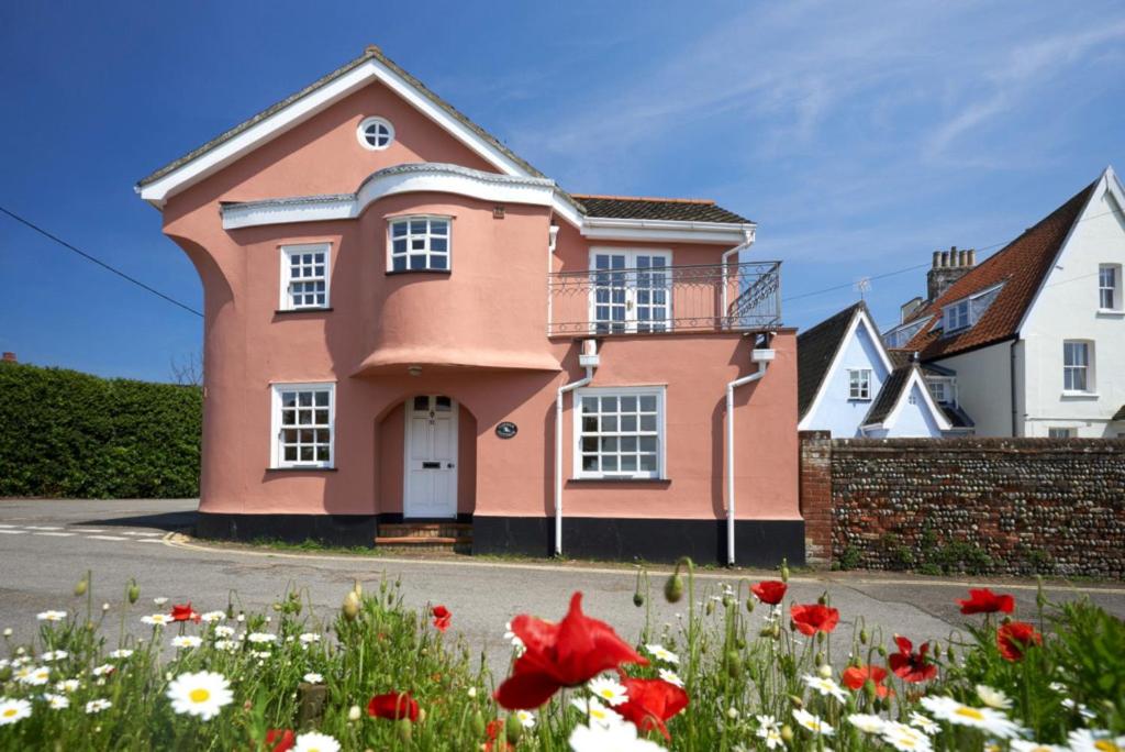 a pink house with flowers in front of it at Corner Cottage - The Pink House in Southwold