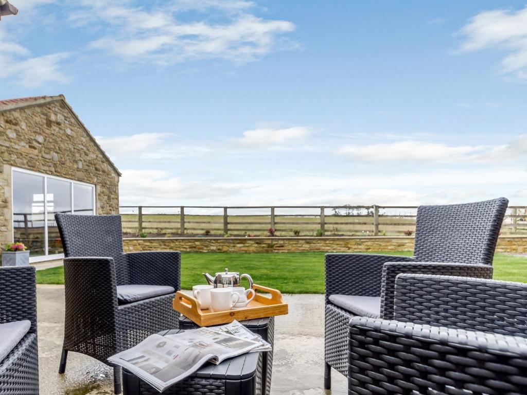 a patio with chairs and a table with a tea set at 2 bed property in Hamsterley 80005 in High Etherley