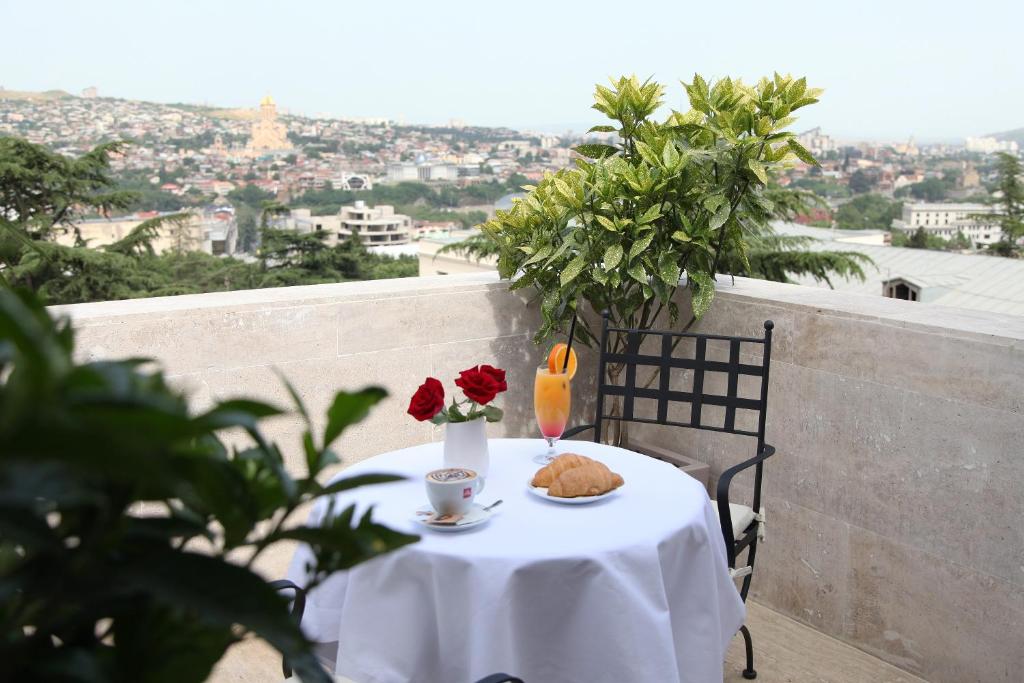 a table with a white table cloth and flowers on it at Citrus Hotel in Tbilisi City