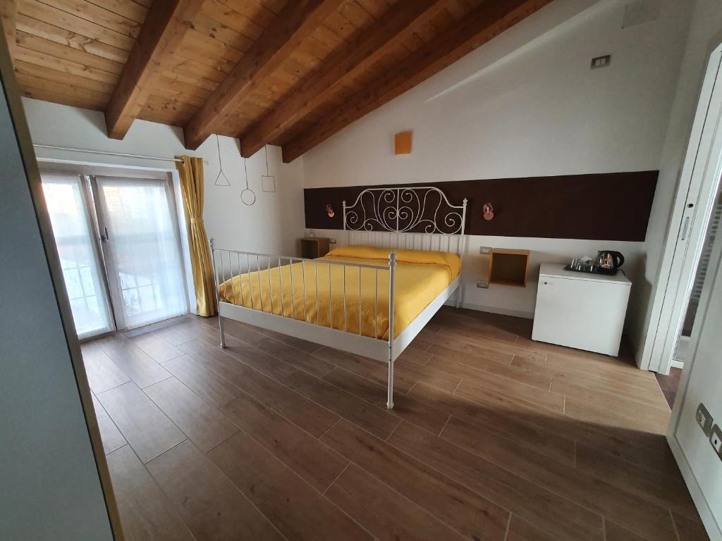 1 dormitorio con cama amarilla y suelo de madera en Elements B&B, en Azzano San Paolo