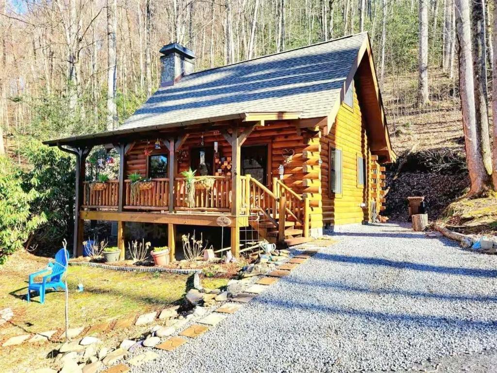 eine Blockhütte mit einer Veranda und einer Terrasse in der Unterkunft Little Wolf Cabin in Maggie Valley