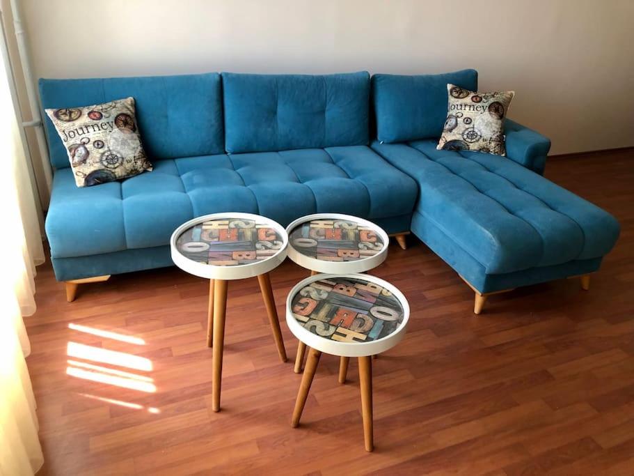 a blue couch in a living room with two tables at Choice of Satisfaction in a Quality Neighborhood in Istanbul