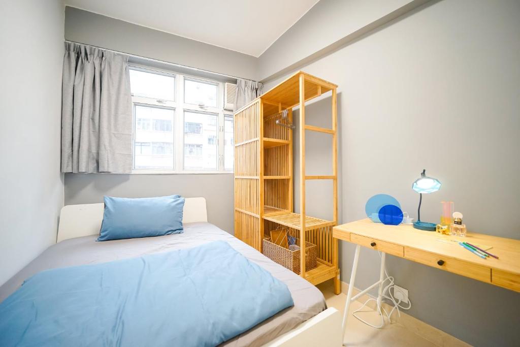 a bedroom with a blue bed and a desk at Student Accommodation - 292 Hennessy Road in Hong Kong