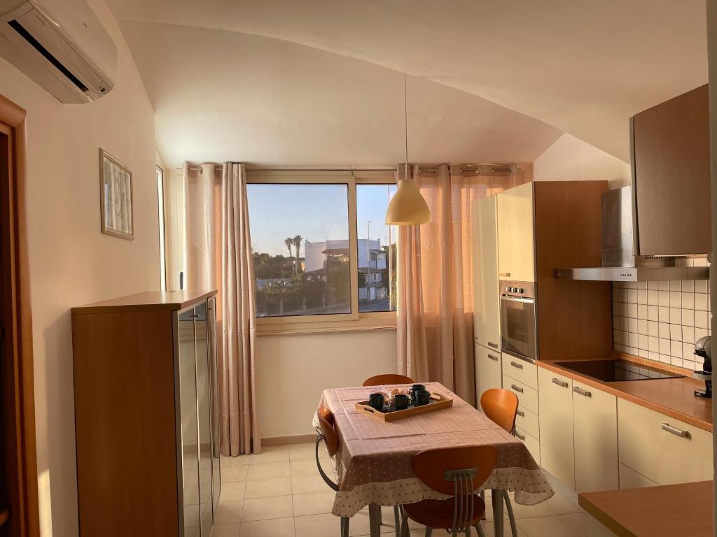 une petite cuisine avec une table et une fenêtre dans l'établissement House Blue Roses Apartment Step Up in Puglia for your Niksen, à Bari