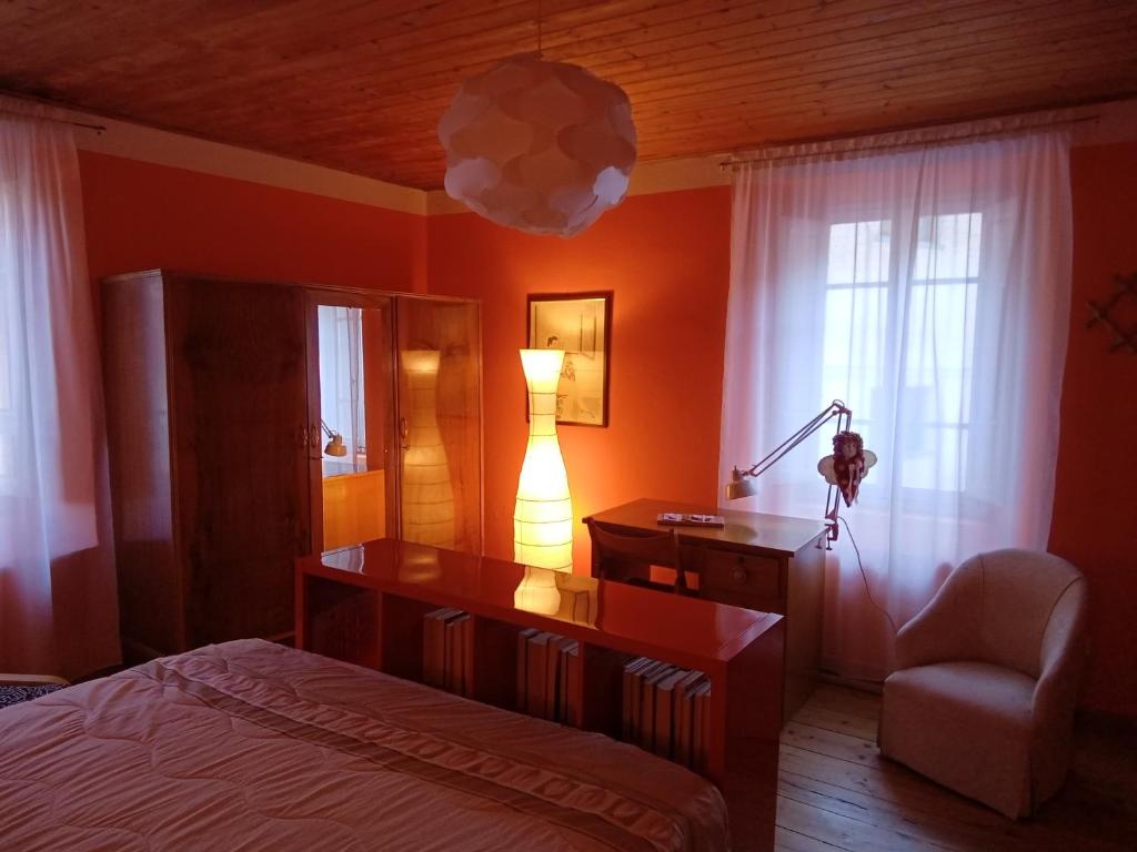 a bedroom with a bed and a desk and a lamp at Casa Pini Rio_A in Riolunato