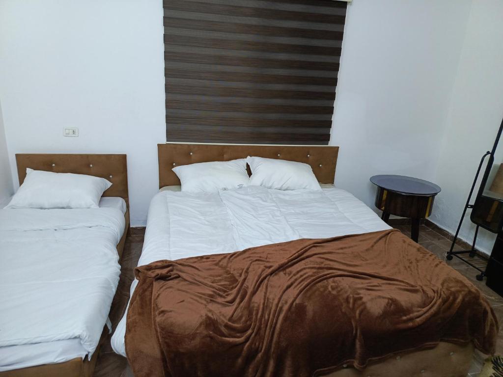 a bedroom with a bed with a brown blanket on it at Jerash Ruins Hotel in Jerash