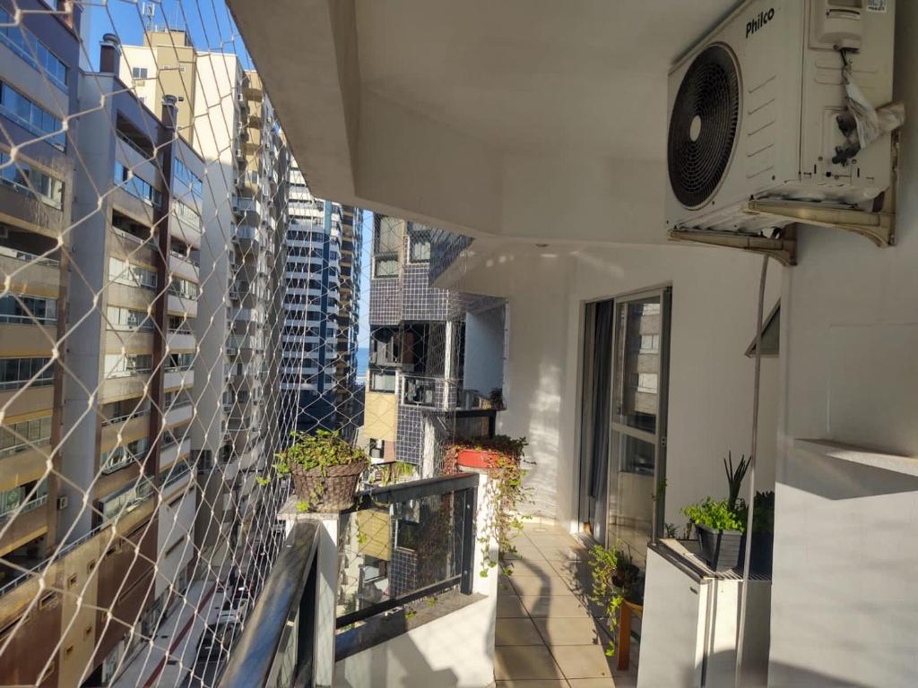 een balkon met potplanten aan de zijkant van een gebouw bij 1 quadra e 1/2 do mar no Centro de Balneário Camboriú! in Balneário Camboriú