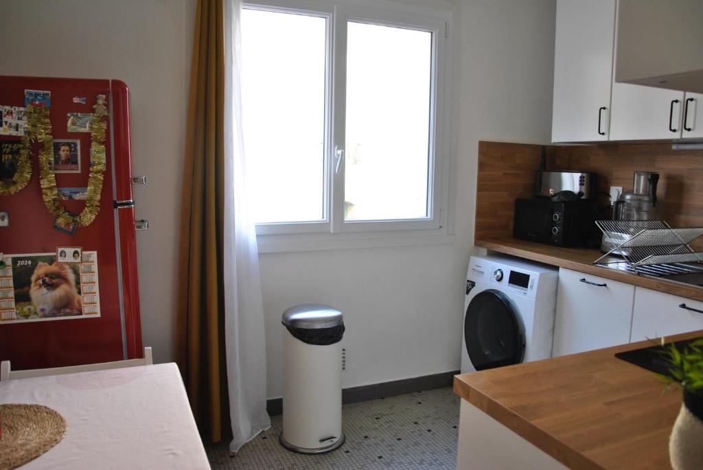 a kitchen with a washing machine and a window at Cocon en centre-ville in Brest