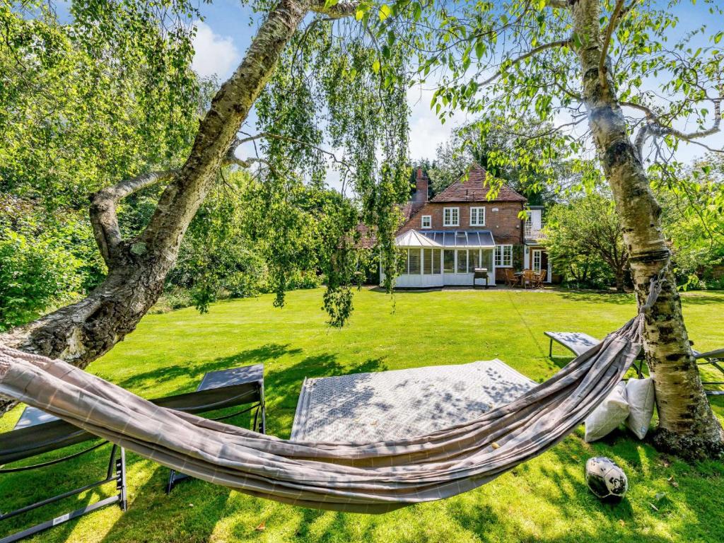 a hammock in a yard in front of a house at 5 Bed in Rye 82395 in Peasmarsh