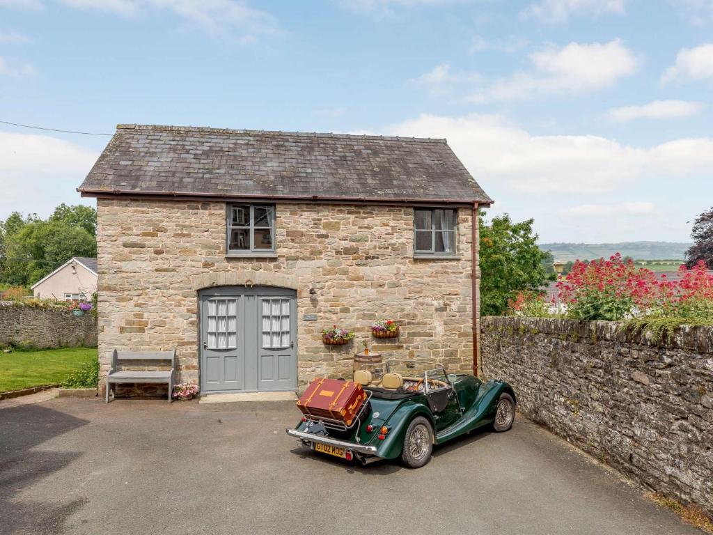 a green car parked in front of a brick building at 3 Bed in Hay-on-Wye 83593 in Hay-on-Wye