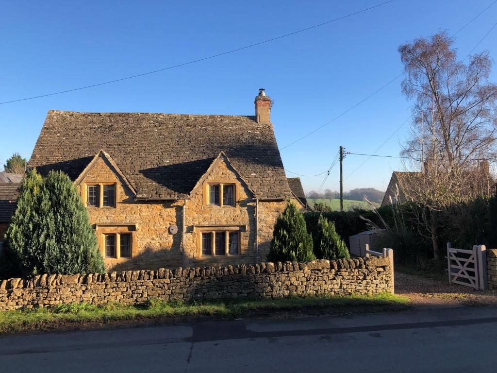 an old stone house with a stone wall at 1 Bed in Longborough 82284 in Longborough