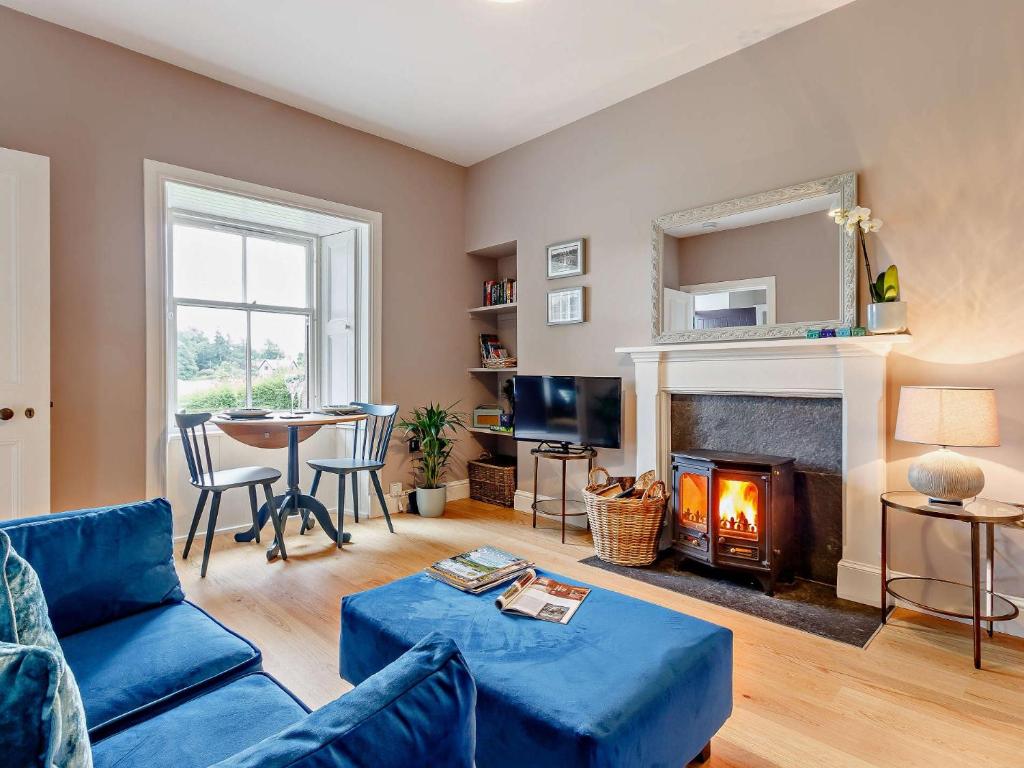 a living room with a blue couch and a fireplace at 1 Bed in Crieff 85244 in Crieff