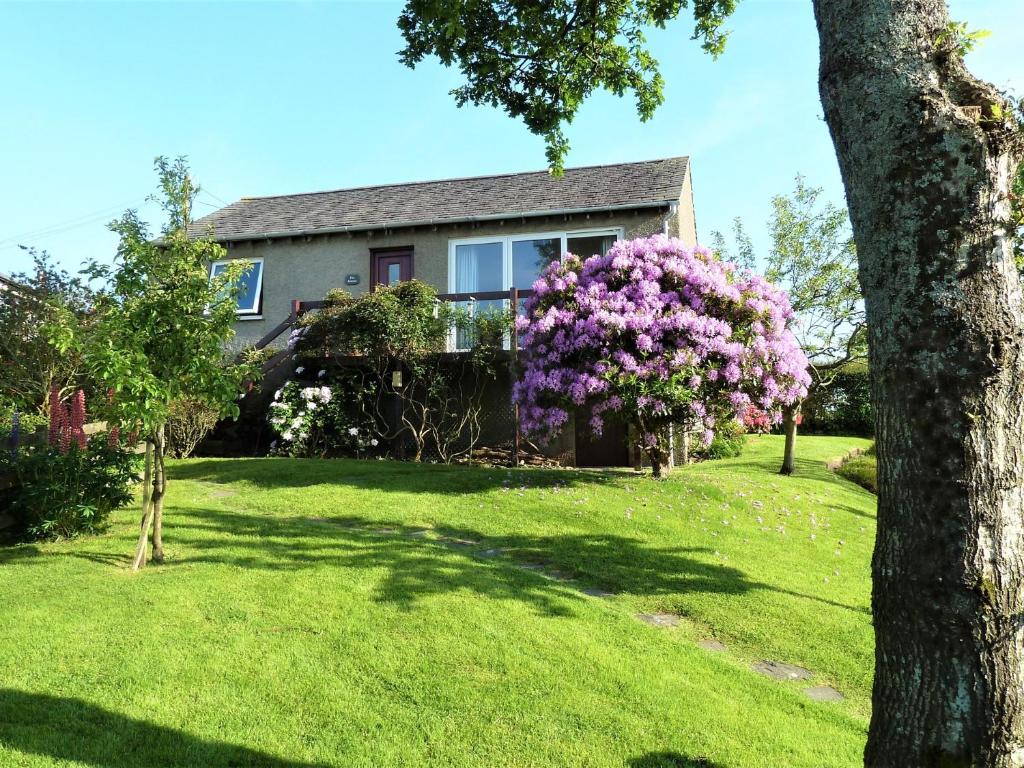 a house with a bush of purple flowers in the yard at 1 Bed in Kirkby-in-Furness SZ463 in Grizebeck