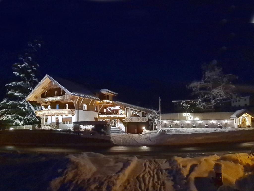 ein Gebäude mit Lichtern im Schnee in der Nacht in der Unterkunft Aparthotel Buchauer-Tirol in Thiersee