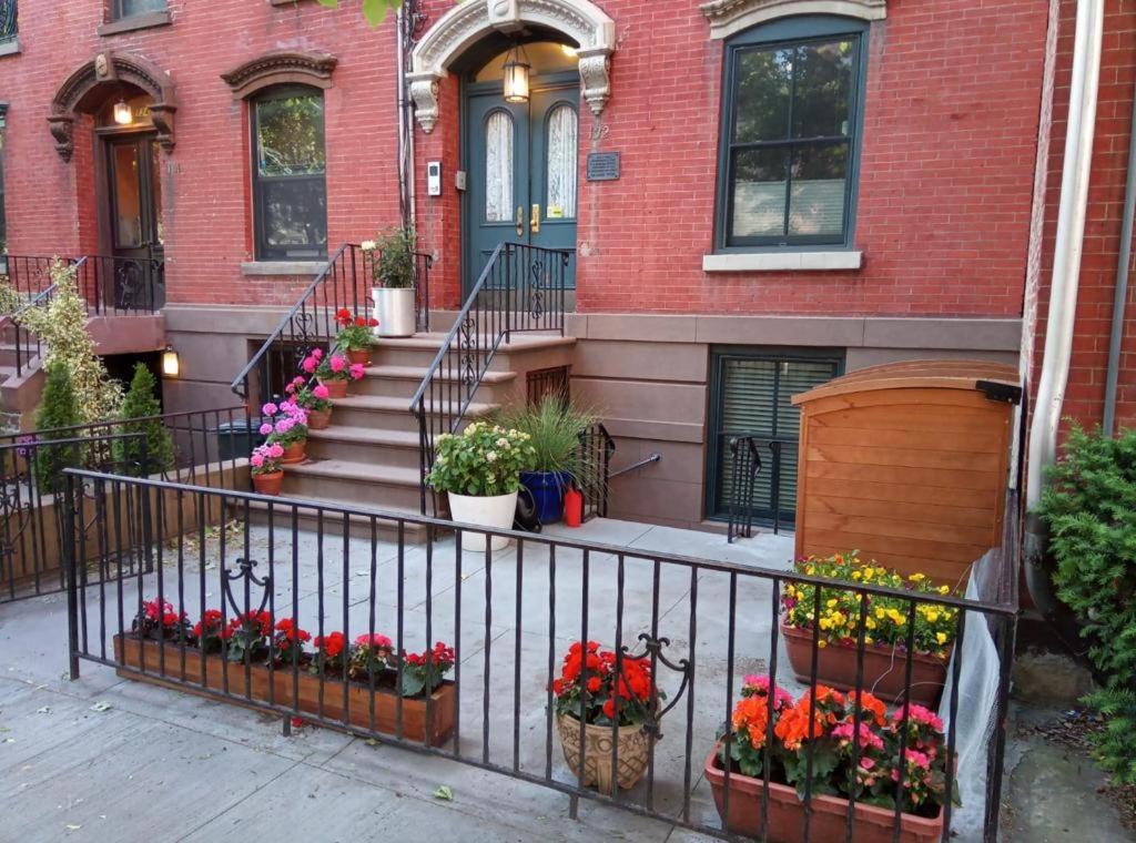 a house with flowers in pots on a fence at Historic 1869 Brownstone 15 min to NYC downtown in Jersey City