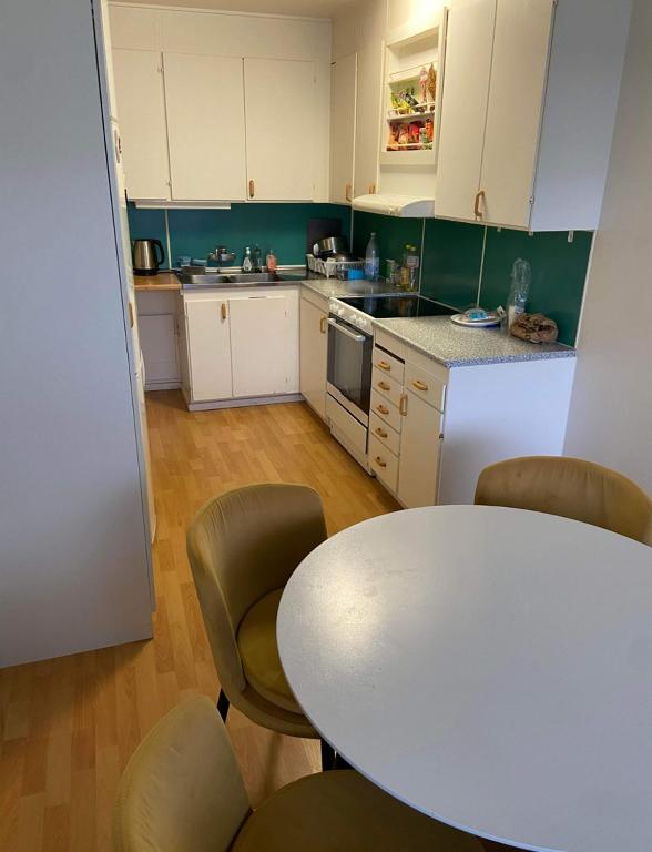 a kitchen with a white table and chairs and a table at lovely apartment in Gothenburg in Gothenburg