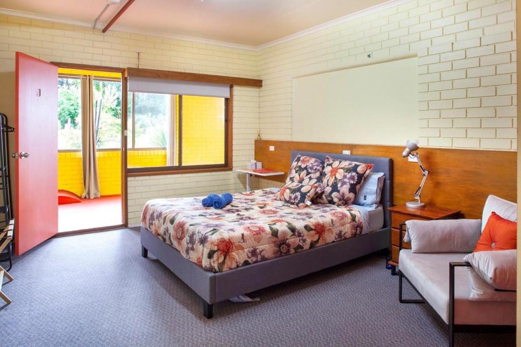 a bedroom with a bed and a couch at Treetops Silvan Valley Lodge - suite 1 in Silvan