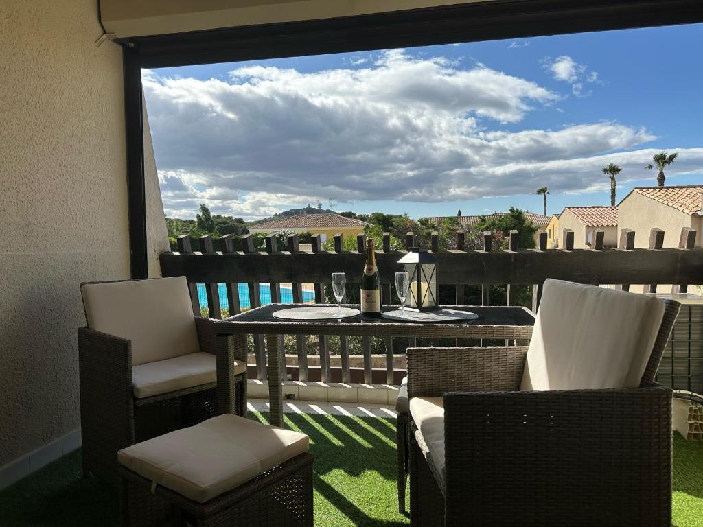 un patio avec une table et des chaises sur un balcon dans l'établissement Village naturiste - Port-Vénus - Studio Le Vénus -, au Cap d'Agde