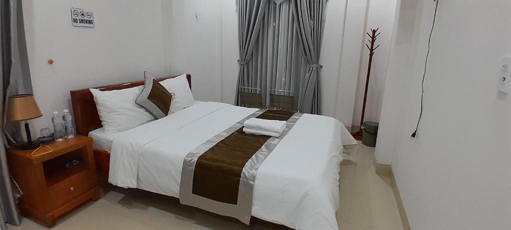 ein Schlafzimmer mit einem großen Bett mit weißer Bettwäsche und Kissen in der Unterkunft Khách sạn 68 ĐỒNG HẢI in Dong Hoi