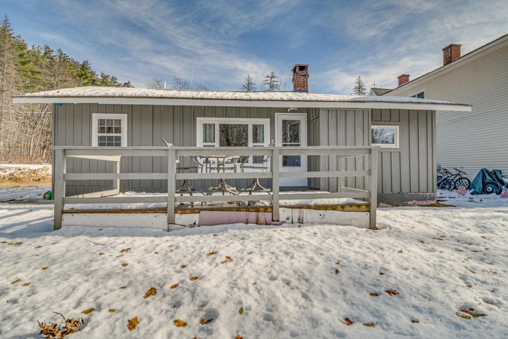 ein Haus mit einer Veranda im Schnee in der Unterkunft Cozy New Hampshire Cottage with Deck, Near Skiing! in Glen