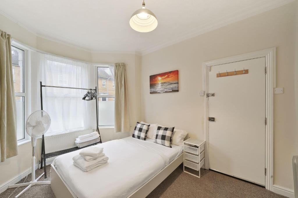 a white bedroom with a bed and a window at LiveStay - One Bedroom Studio Near The Beach in Southend-on-Sea