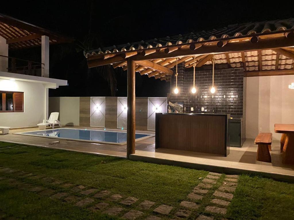 um quintal com uma piscina à noite em Casa Barra Grande em Maraú