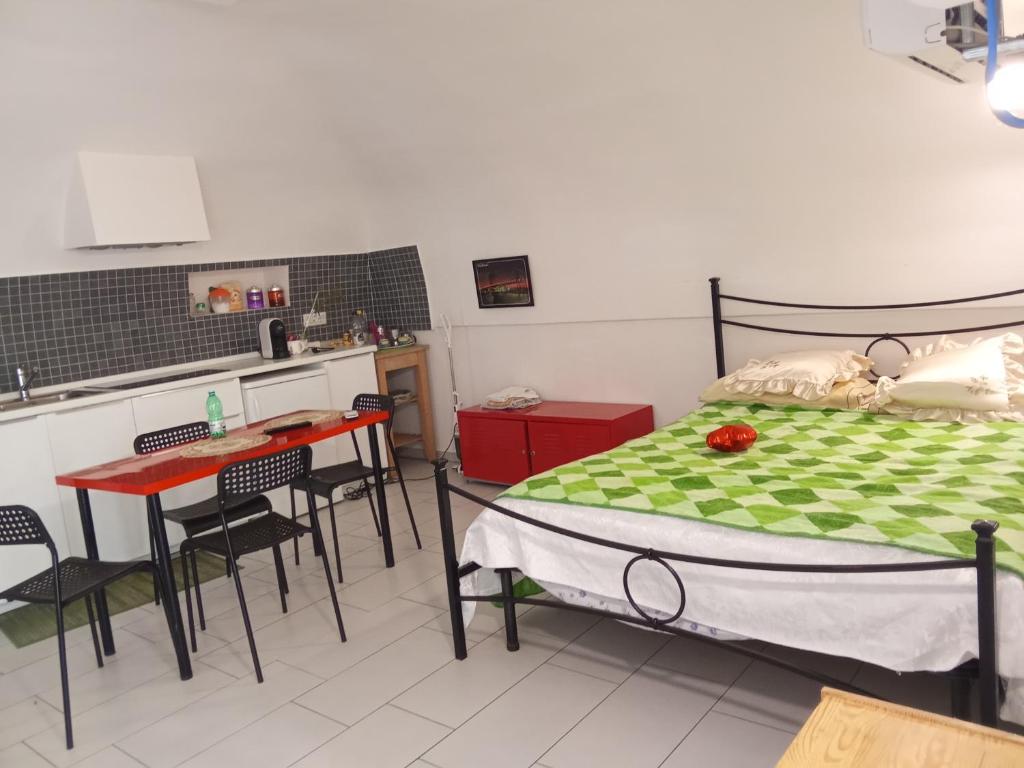 ein Schlafzimmer mit einem Bett und einem Tisch sowie eine Küche in der Unterkunft Mary's house in Portici