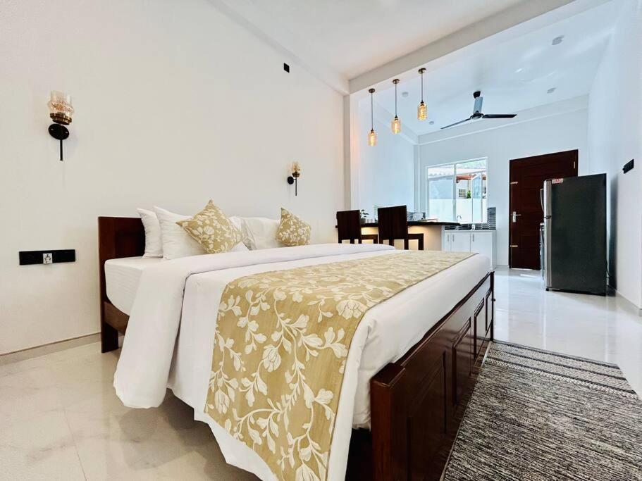 een witte slaapkamer met een groot bed en een keuken bij The Palazzo - Weligama in Weligama