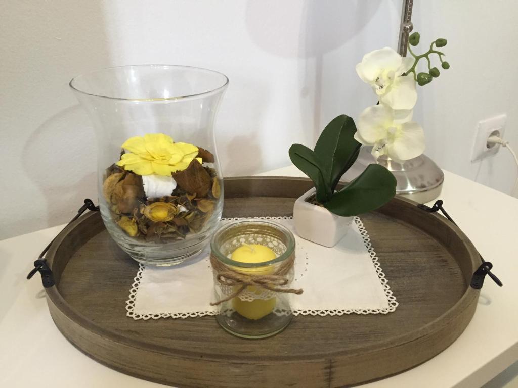 a tray with a vase and flowers on a table at San Juan Apartamento in Jerez de la Frontera