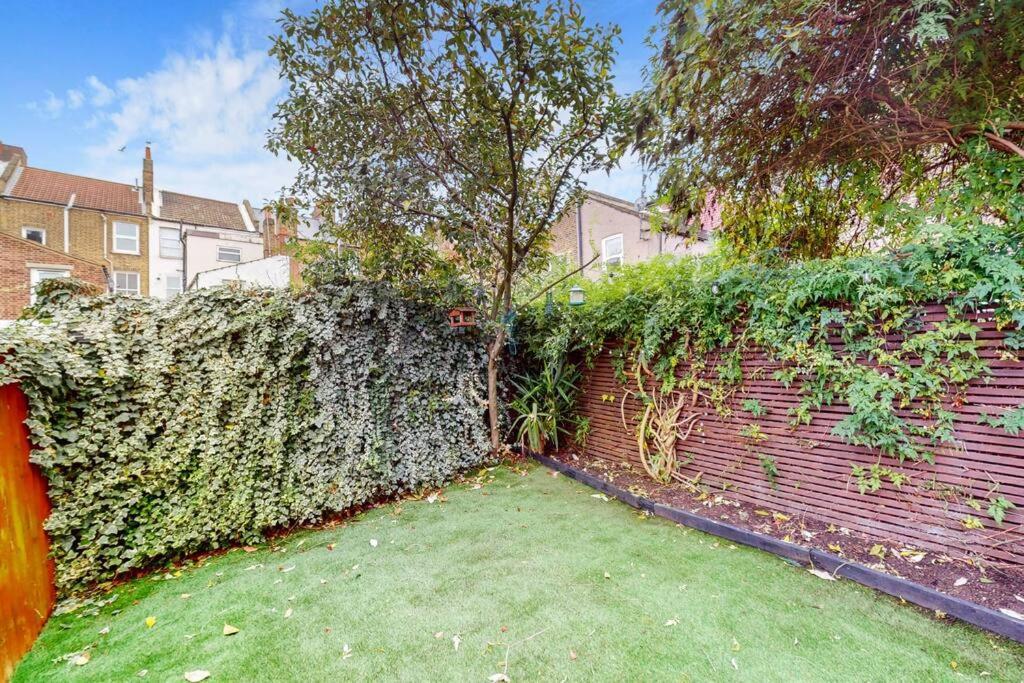 a brick wall with a tree on top of it at Stunning 2BDR with beautiful garden in London