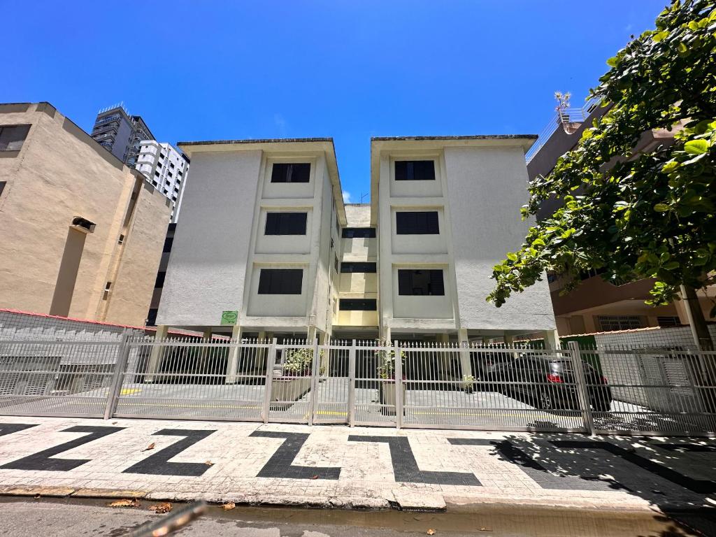 uma cerca de metal em frente a um edifício em Apartamento Temporada Guarujá no Guarujá