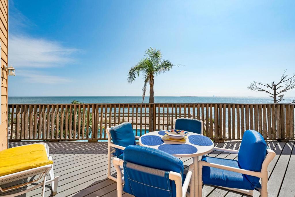 un tavolo e sedie su una terrazza con spiaggia di 069 Sandcastle 5F a Dauphin Island