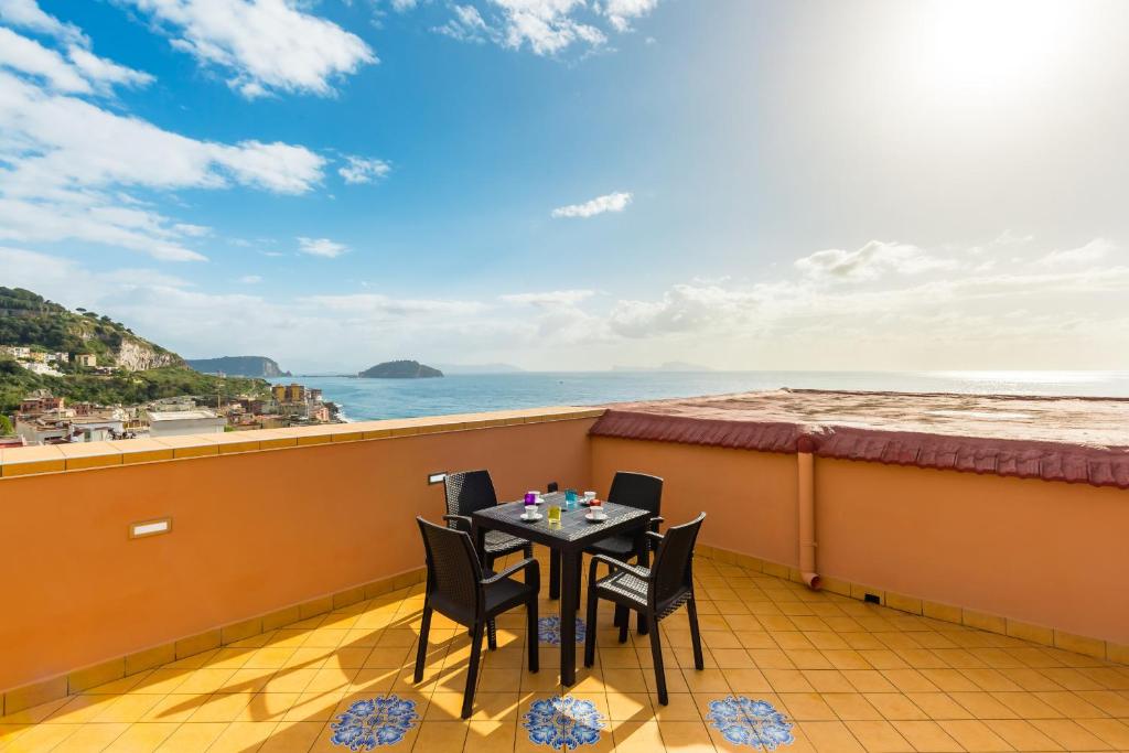 Una mesa en un balcón con vista al mar. en Nisida View Apartment by Wonderful Italy, en Pozzuoli
