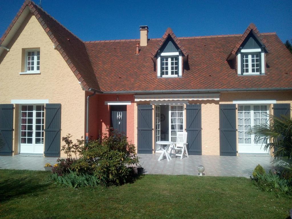 una casa con mesa y sillas en el patio en 2 Chambres chez l habitant, en Parigné-lʼÉvêque